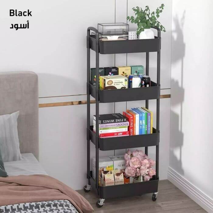 Black metal rolling cart with books and decorative items in a bedroom setting